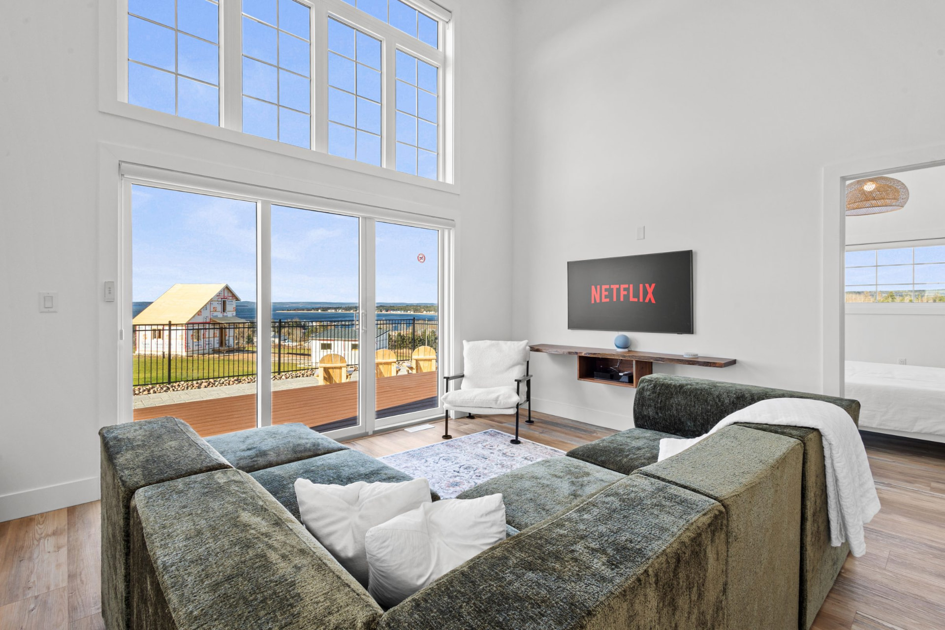 Bright open-concept living room with large windows looking out to the ocean